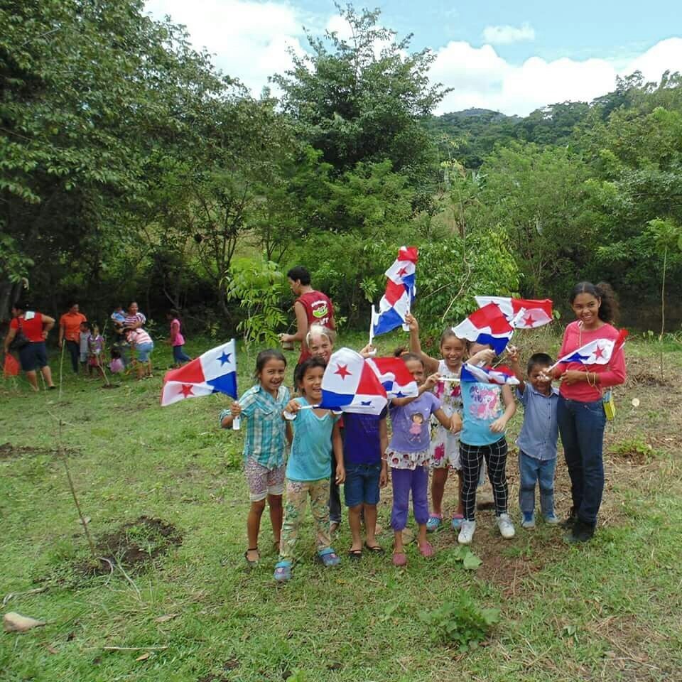 Children from a nearby community waving Panamanian flags during the National Tree Reforestation Program - Cerro Chucantí.
